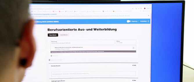 Eine Frau vor dem PC füllt die Steuererklärung aus und trägt dabei auch die Weiterbildungskosten ein, um finanziell zu profitieren.